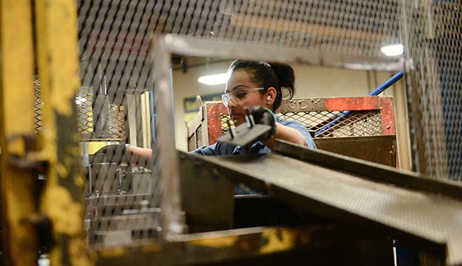 Metal Stamping Warehouse employees cleaning and stamping automotive parts